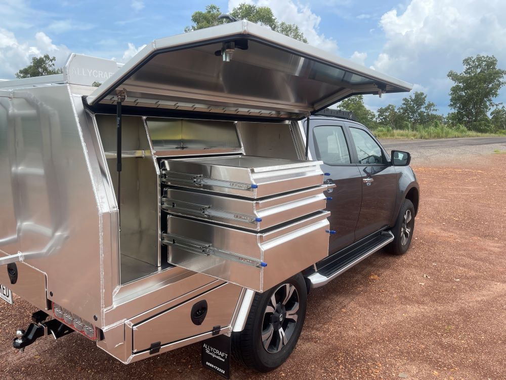A Silver Truck With a Canopy and Drawers on the Back is Parked on a Dirt Road — Allycraft Modifications in Berrimah, NT