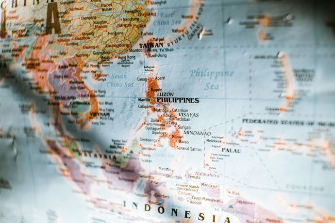 A close-up, angled view of a colorful world map centered on the Philippines, Southeast Asia, and Indonesia.
