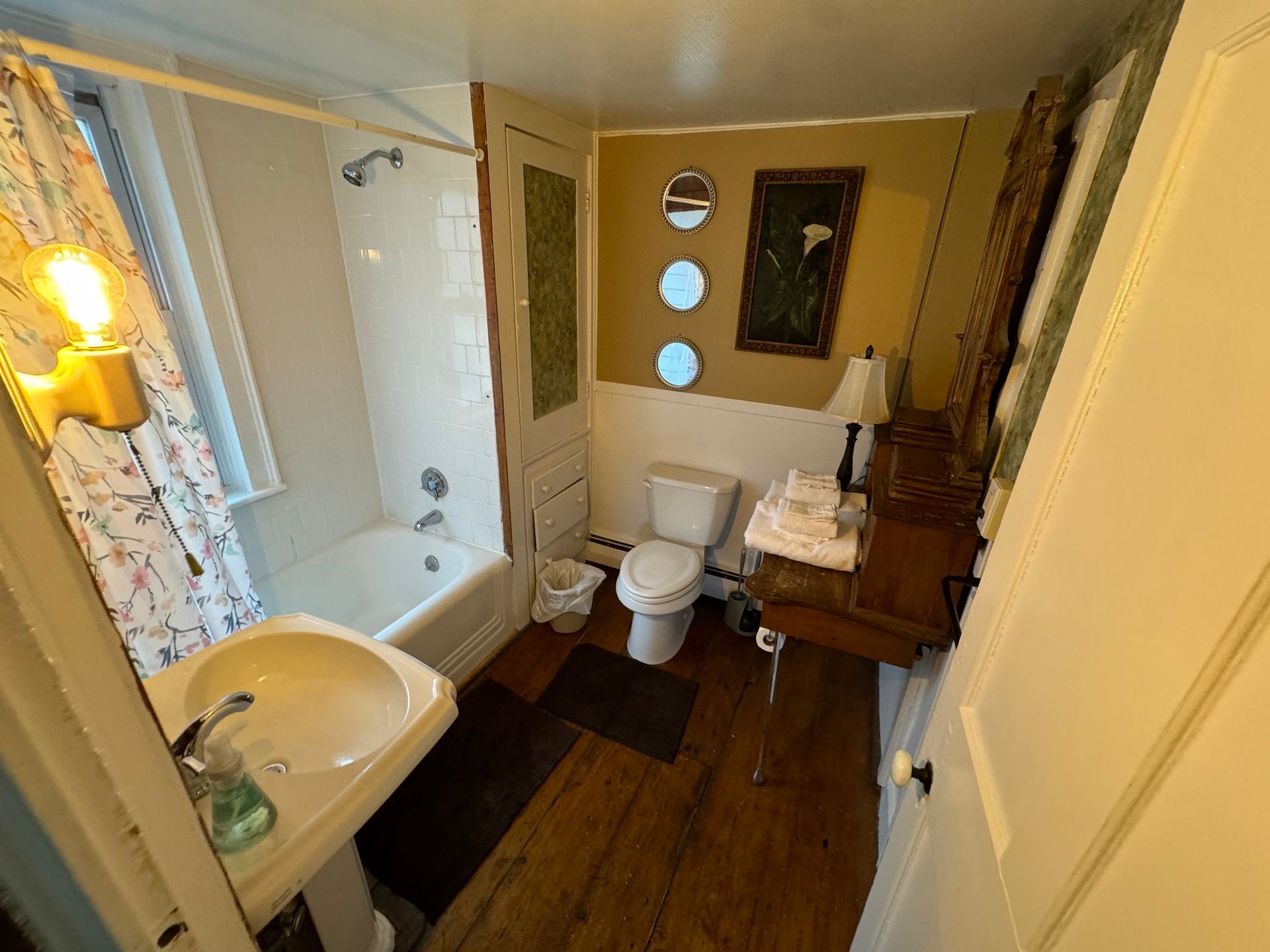 A bathroom with a sink , toilet , bathtub and mirror.