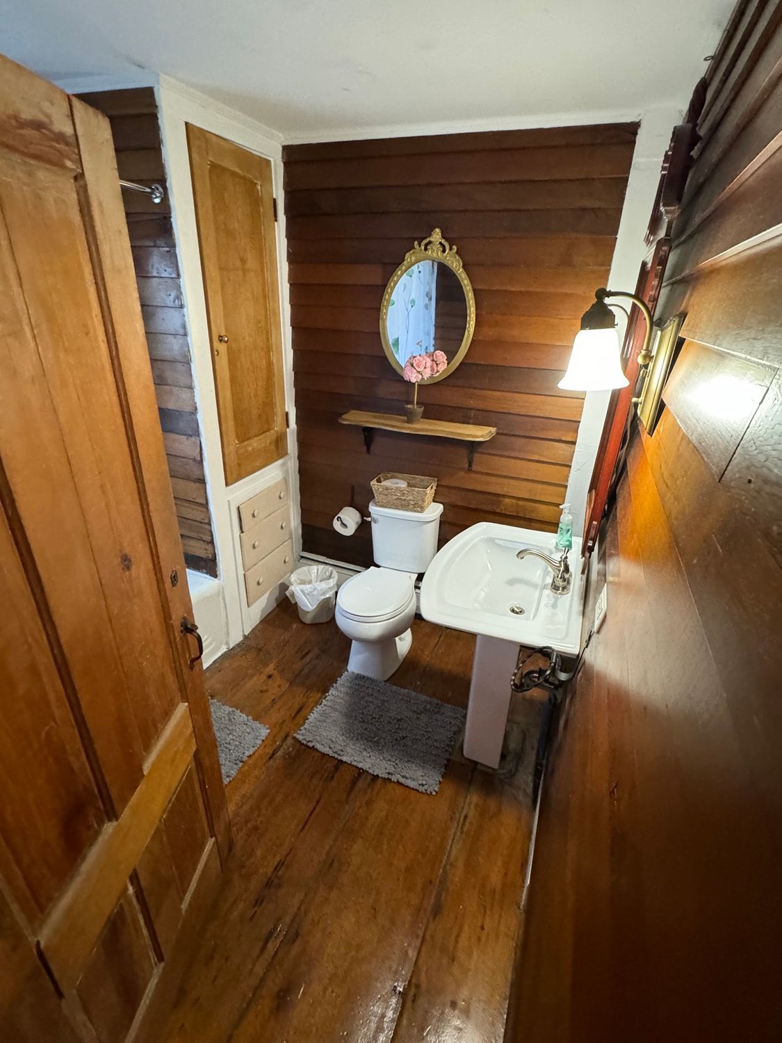 A bathroom with a toilet , sink and mirror.