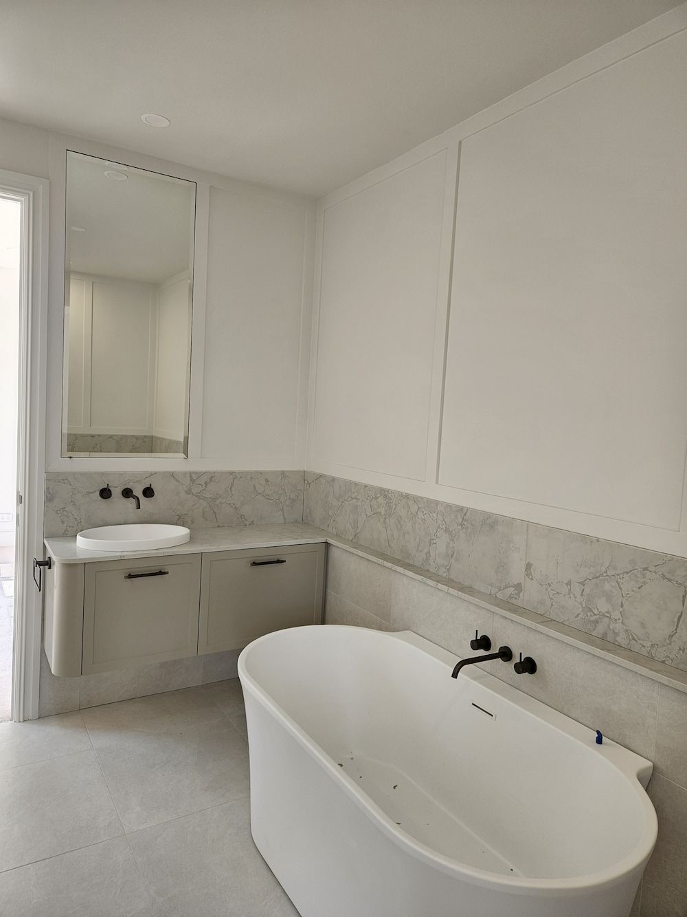 Modern Bathroom With a White Bathtub, Vanity, and Marble Accents — Kolora Projects in Robina, QLD