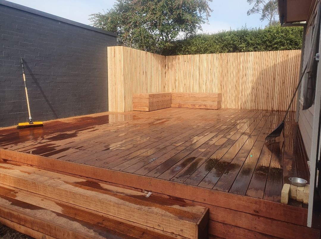 Wooden Deck With a New Wooden Fence in the Background, Set Outdoors — Kolora Projects in Robina, QLD