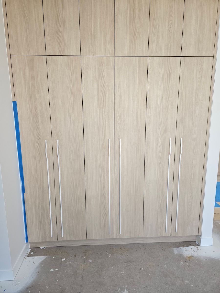 Light Wood Grain Closet Doors With Vertical Silver Handles and Decorative Cuts — Kolora Projects in Robina, QLD