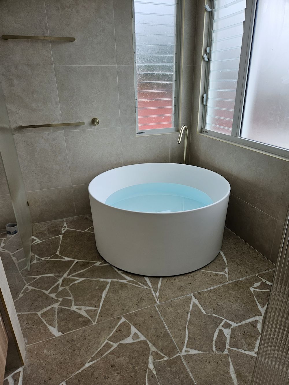 Round White Bathtub Filled With Water in a Modern Bathroom — Kolora Projects in Robina, QLD