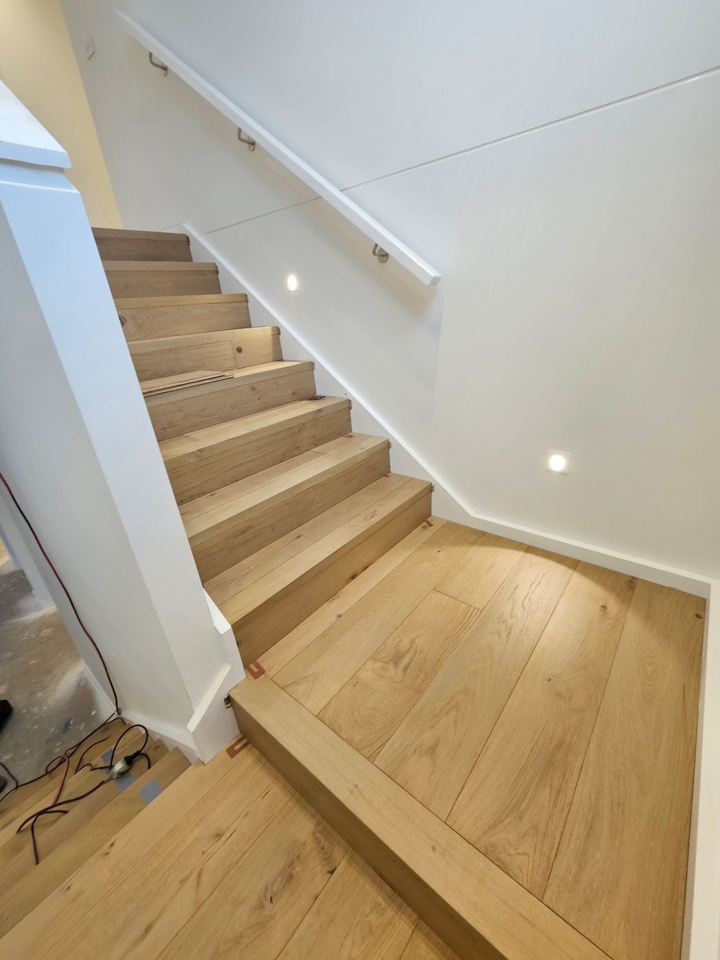 Wooden Staircase With White Walls and a Handrail. Recessed Lighting — Kolora Projects in Robina, QLD