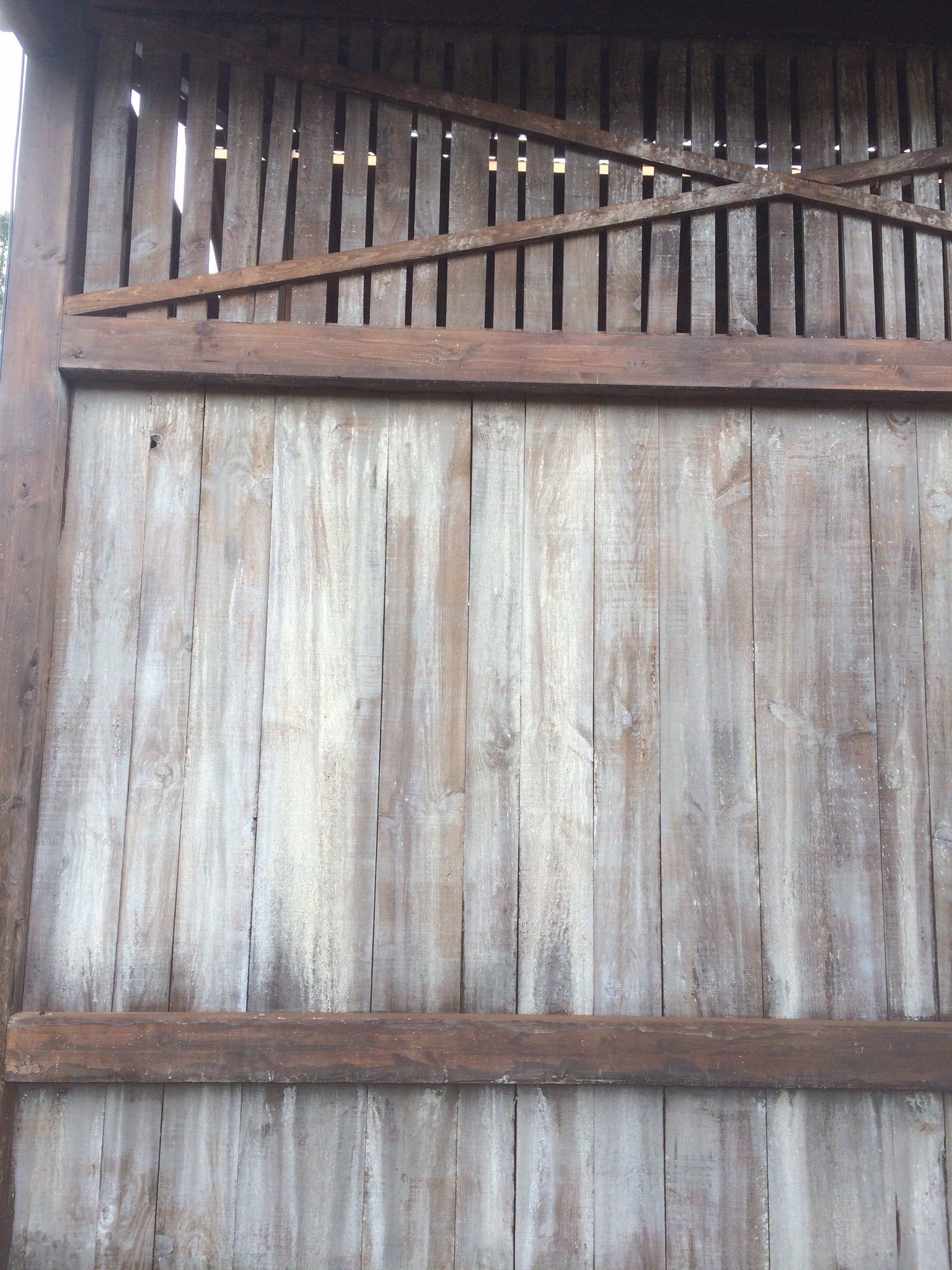 Un primer plano de una valla de madera con agujeros.