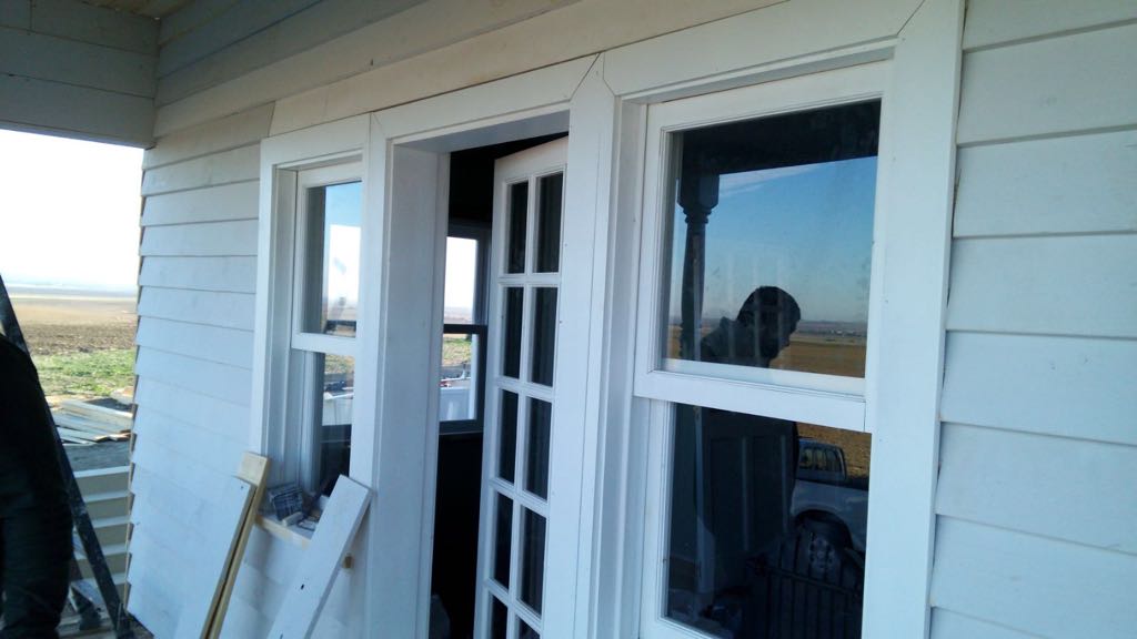 Una casa blanca con una ventana y una puerta rotas