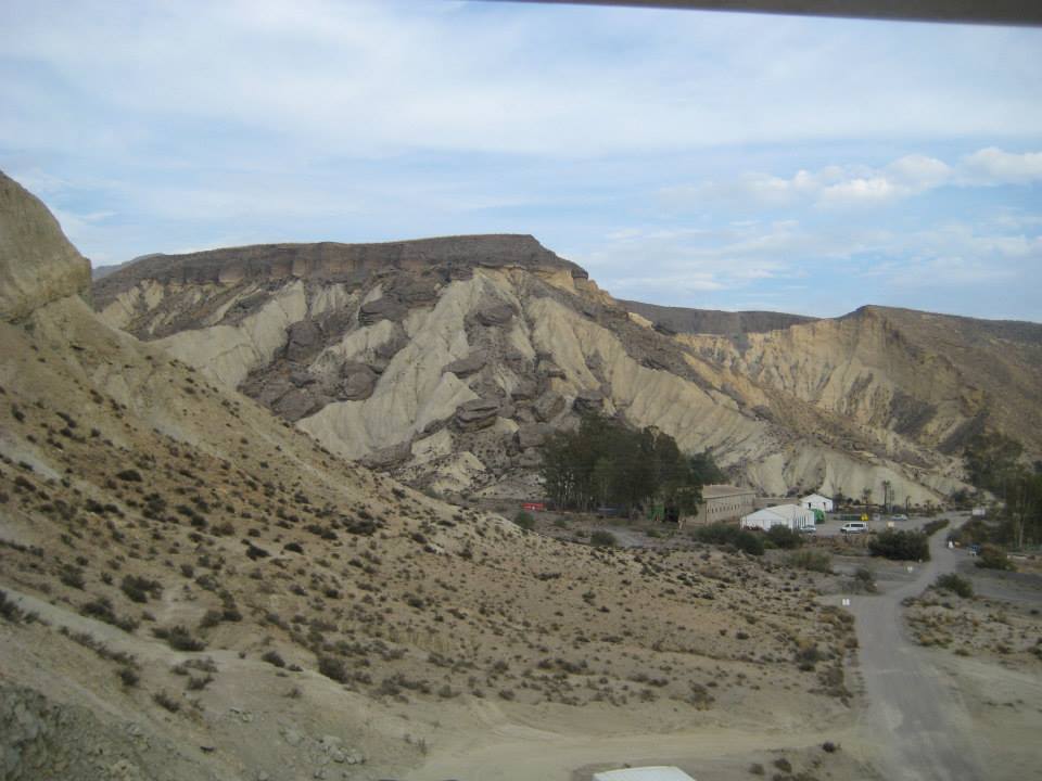 Un paisaje desértico con montañas y una carretera en primer plano.
