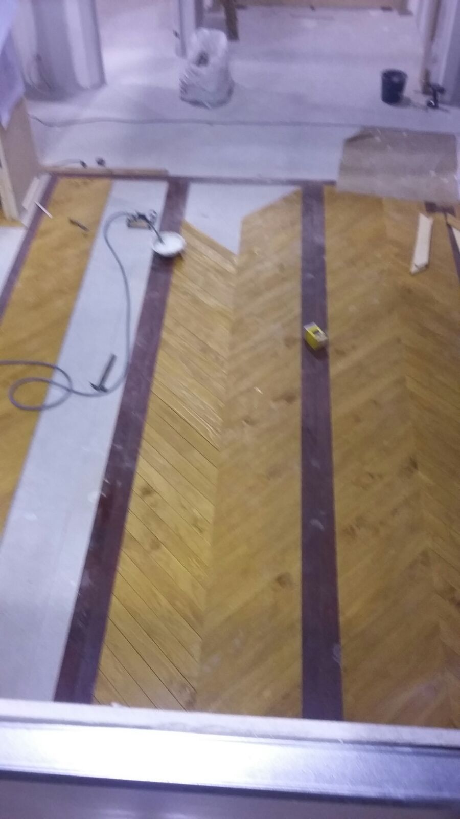 Se está instalando un suelo de madera en una habitación.