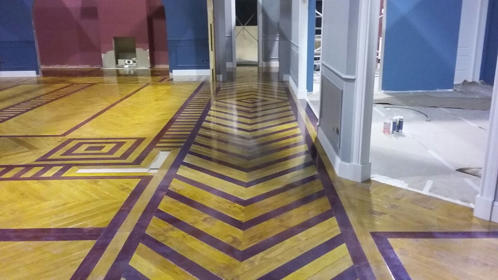 Un pasillo con un patrón de chevrones amarillos y morados en el suelo.