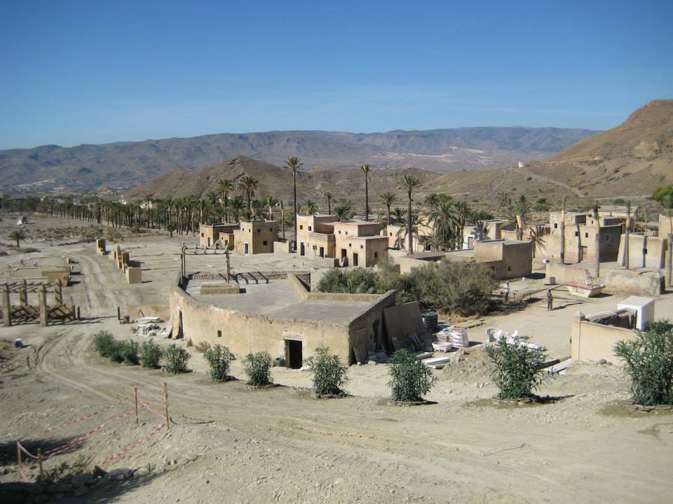 Una vista aérea de un pueblo del desierto con montañas al fondo.