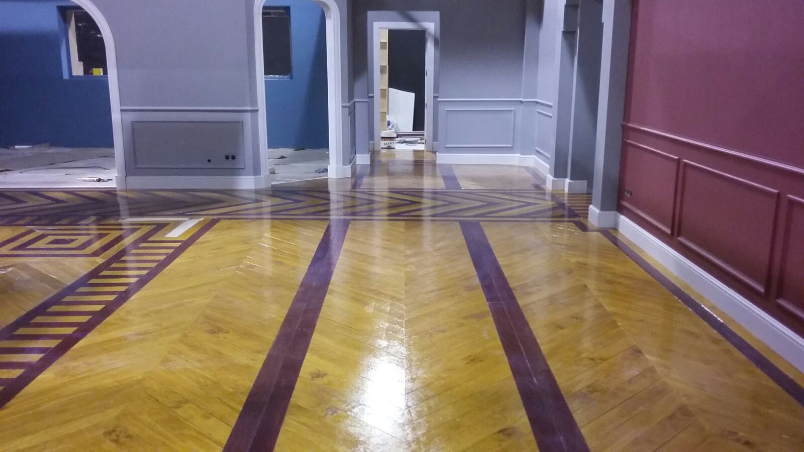 Un pasillo con suelo de madera y paredes rojas.