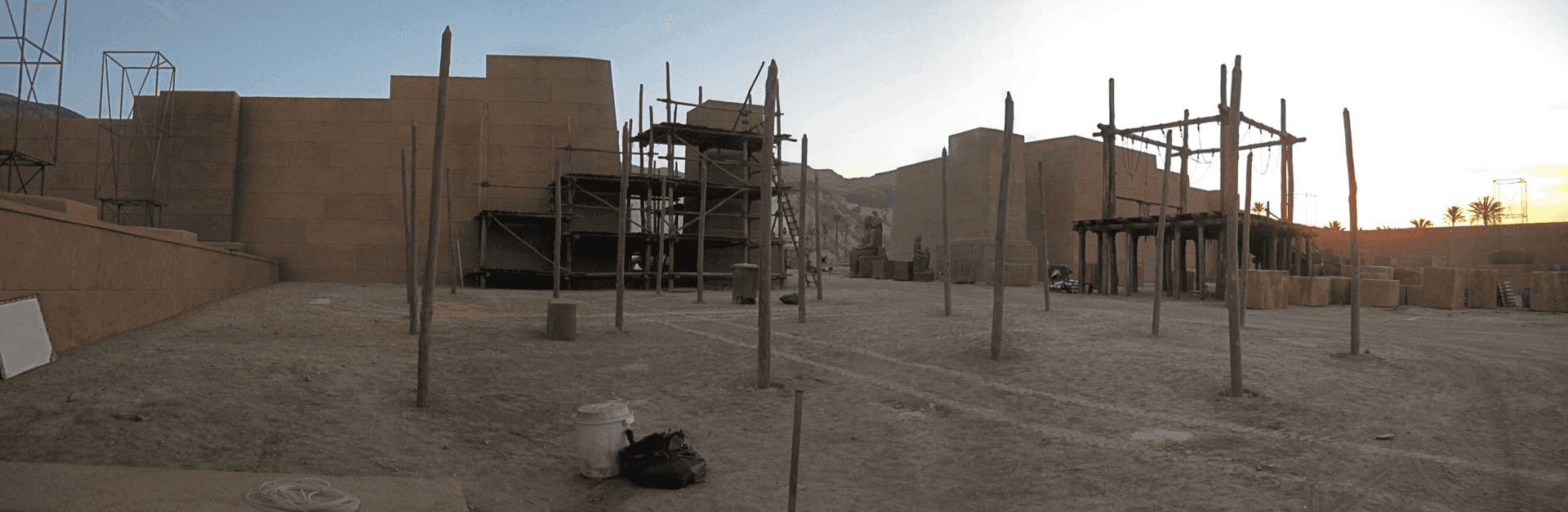 Un gran edificio con muchos postes de madera delante de él.