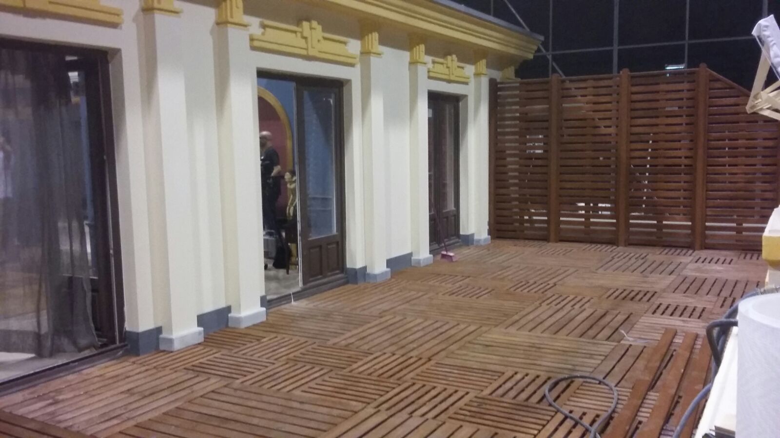 Hay una terraza de madera delante de un edificio.