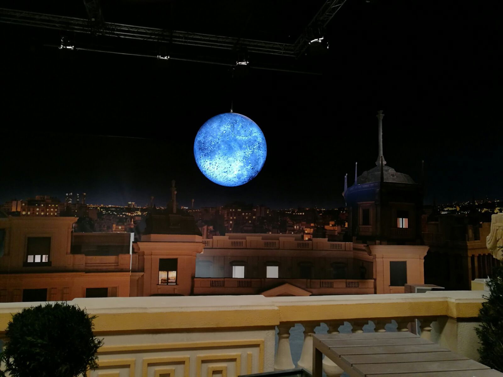 Una luna llena es visible sobre una ciudad por la noche