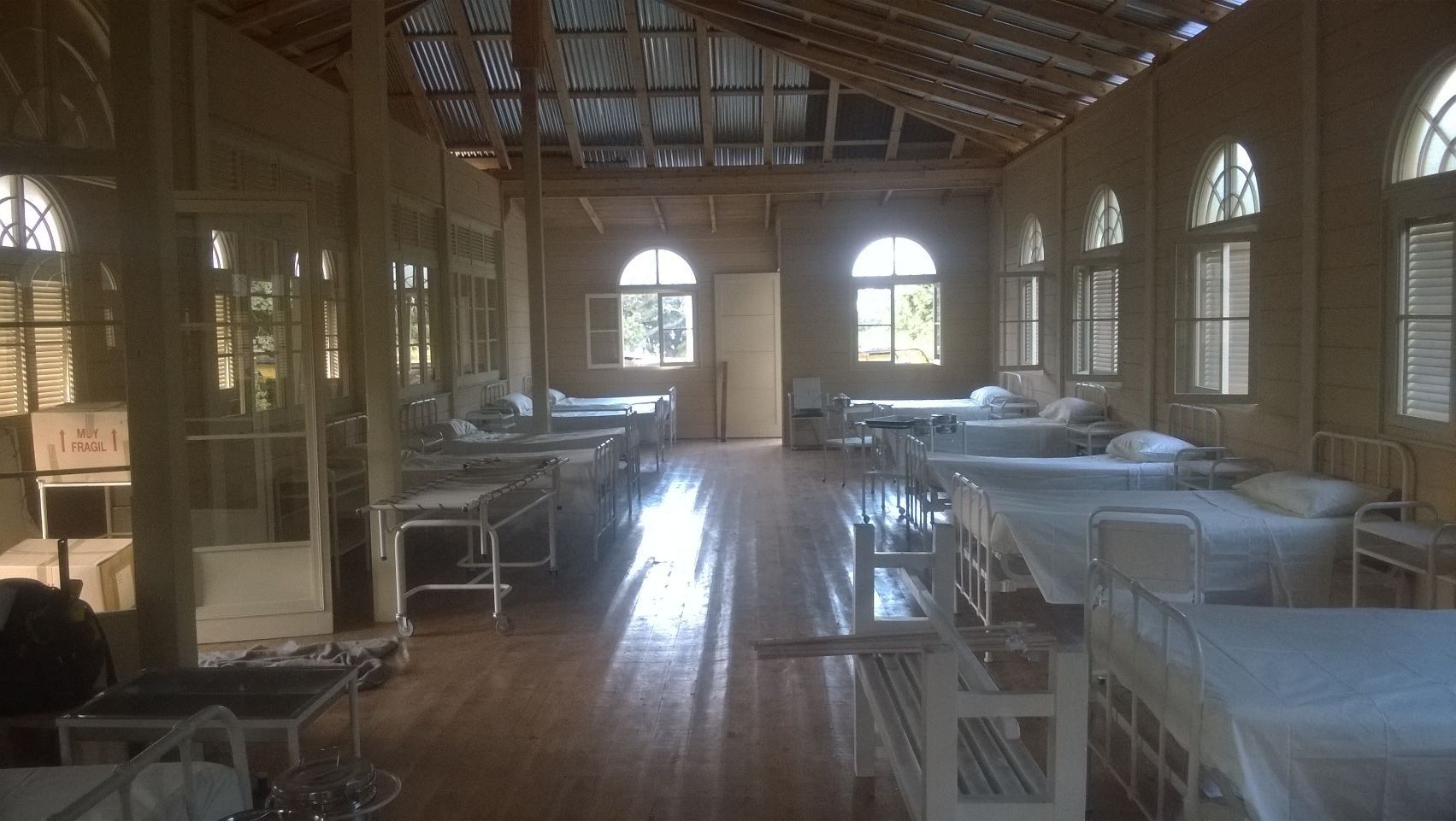 Una habitación de hospital llena de muchas camas y sillas.