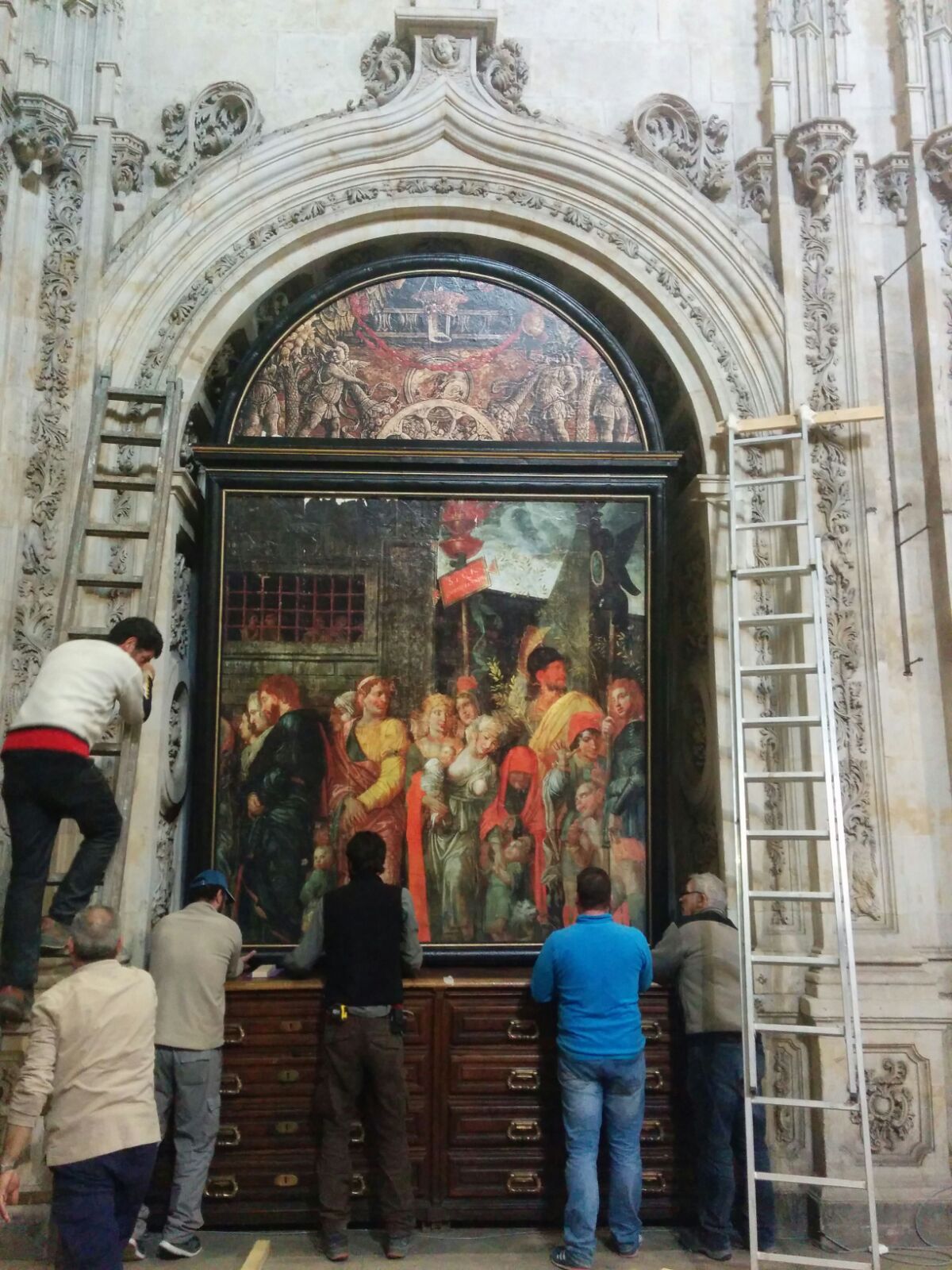 Un grupo de personas está trabajando en una pintura grande.