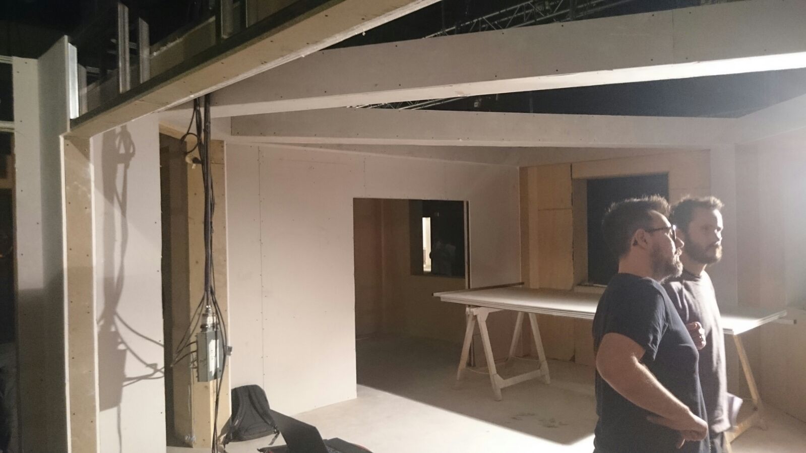 Dos hombres están de pie en una habitación mirando algo.