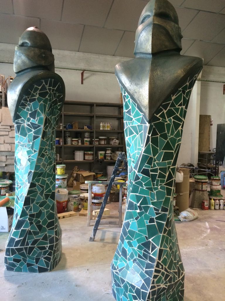 Dos pilares verdes con una estatua encima de ellos.