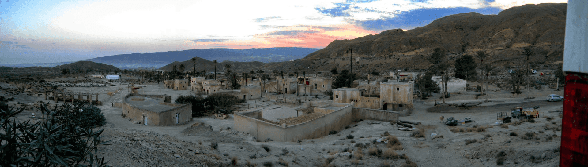 Un paisaje desértico con una bandera roja y blanca en primer plano.