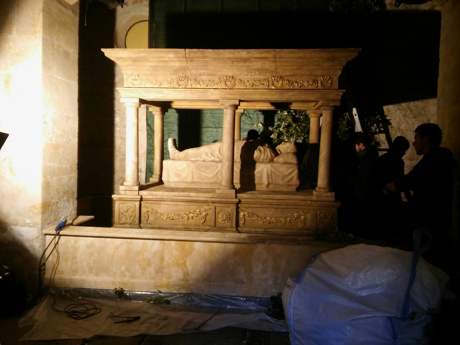 Un grupo de personas está de pie alrededor de una gran escultura de piedra.