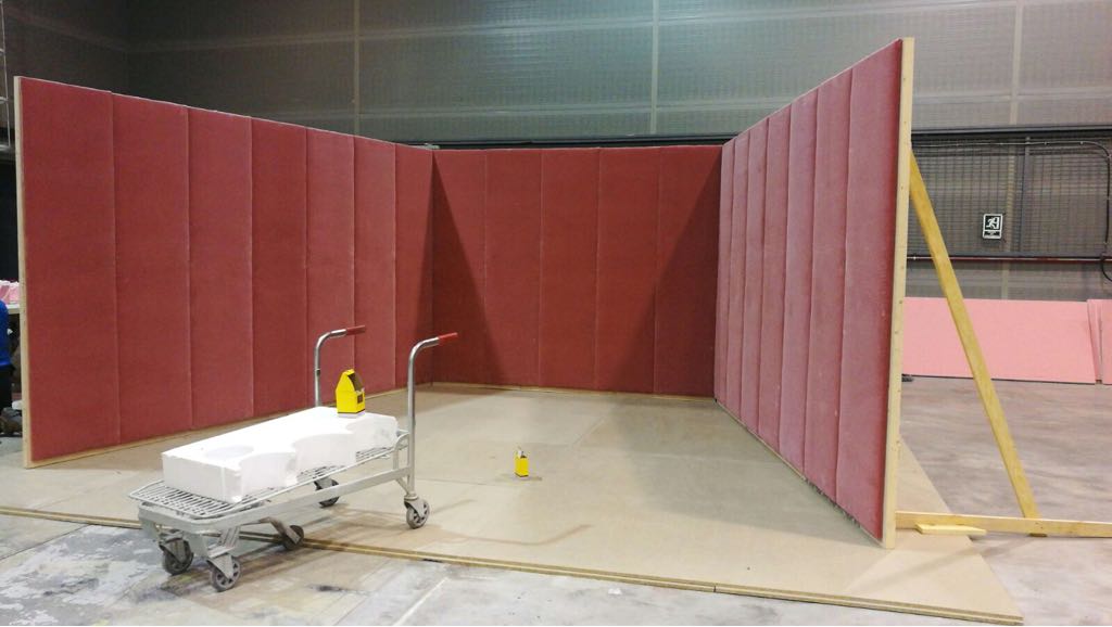 Un carrito está parado frente a una pared roja en una habitación.