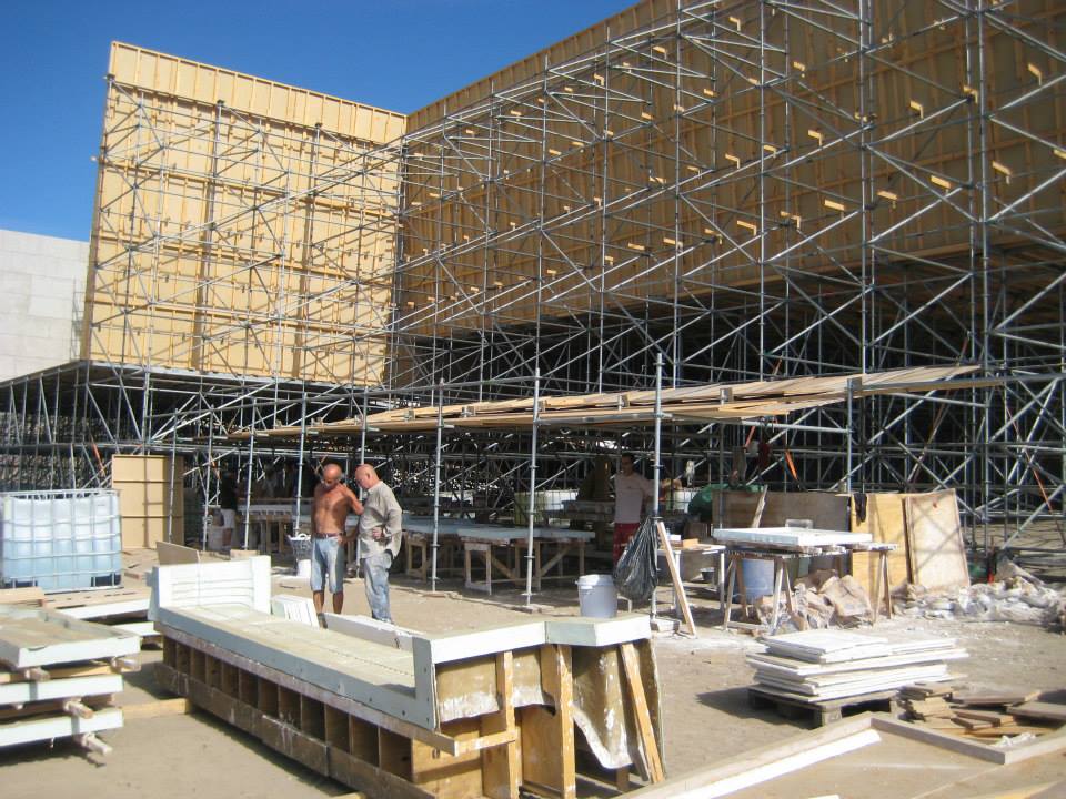 Dos hombres de pie frente a un edificio en construcción
