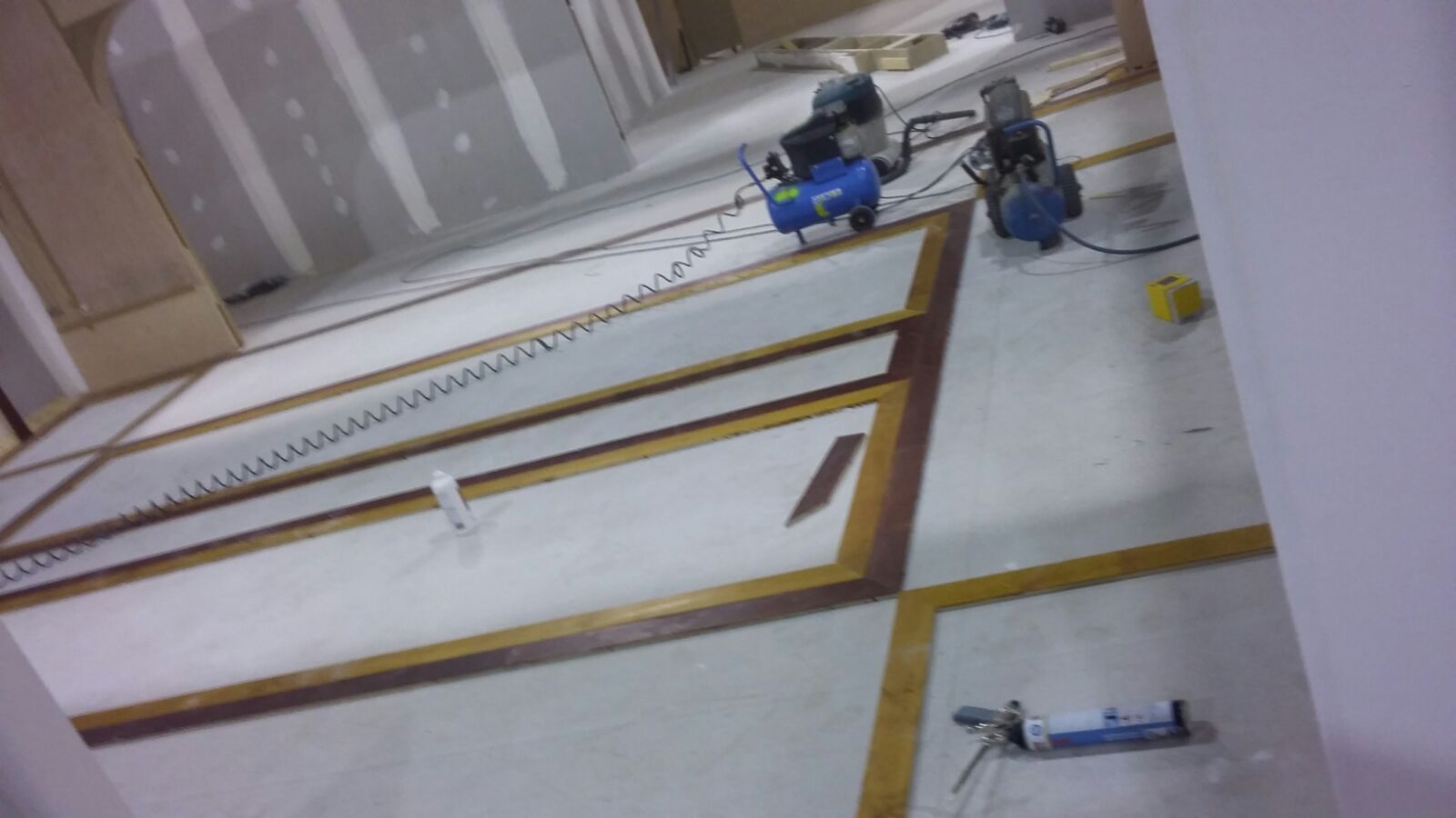 Dos compresores de aire están sentados en el suelo de una habitación.