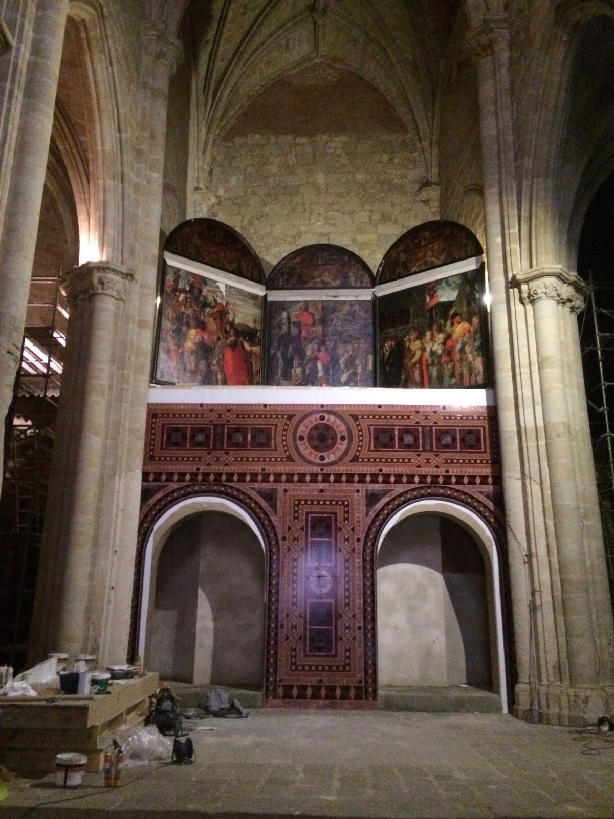 El interior de una iglesia con arcos y pinturas en las paredes.