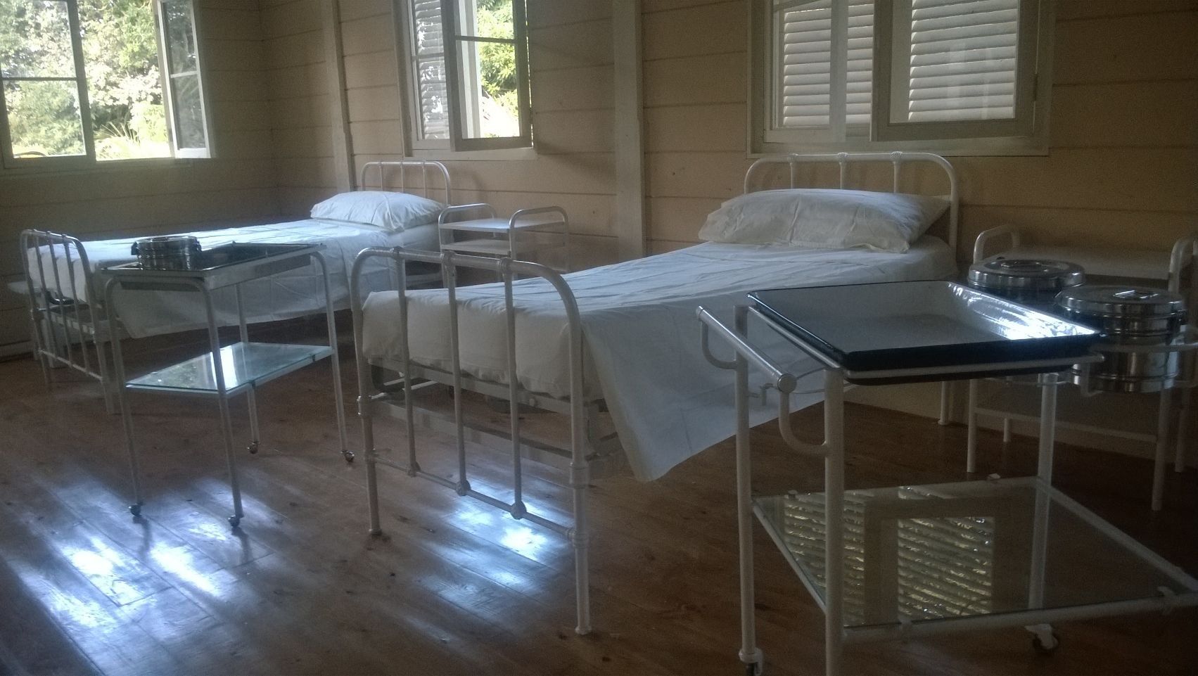 Una habitación con tres camas y un carrito dentro.