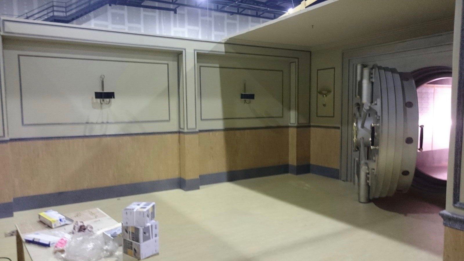 Una habitación con una puerta bóveda y una mesa con cajas encima.