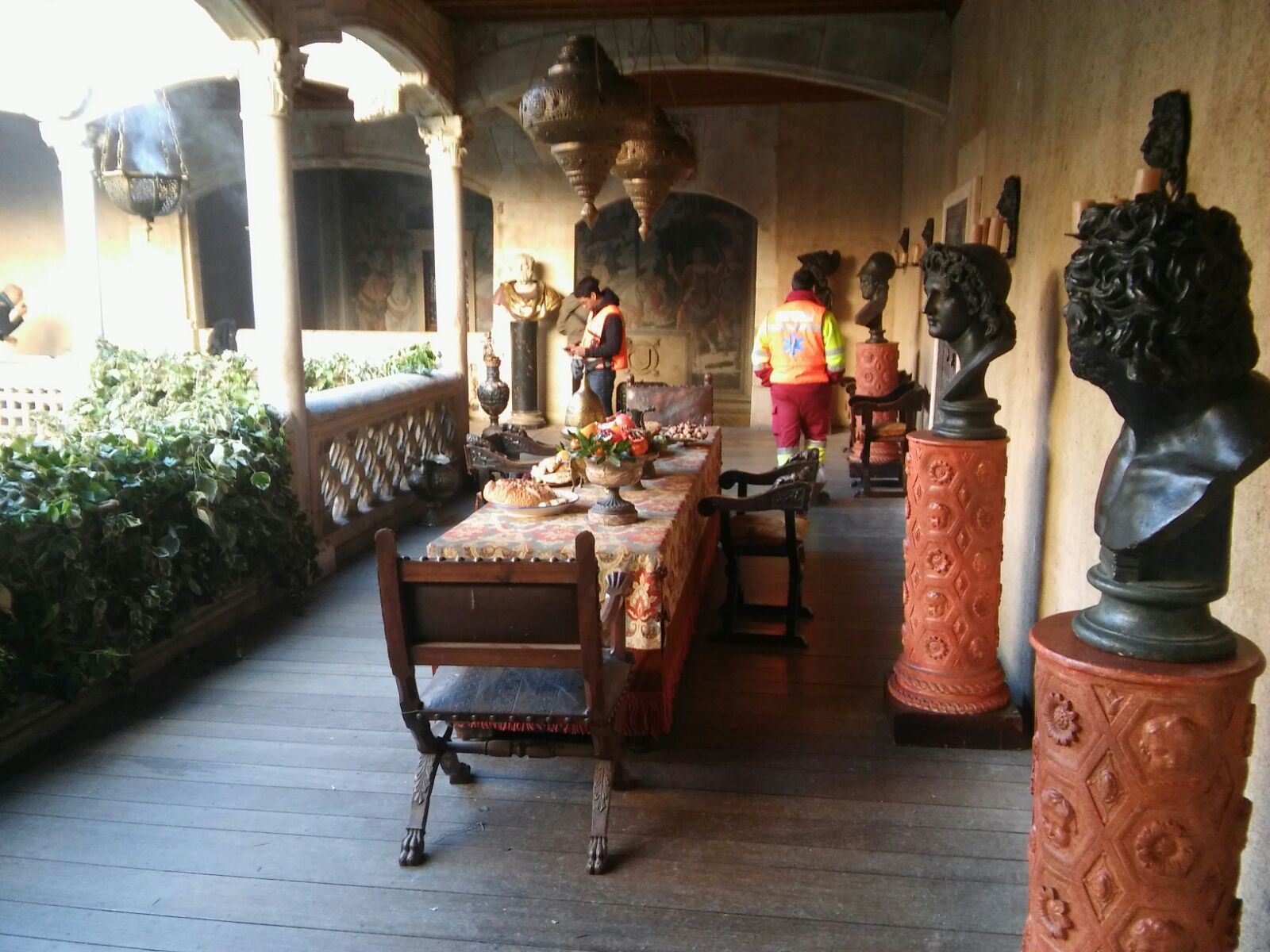 Un comedor con mesa y sillas y estatuas.