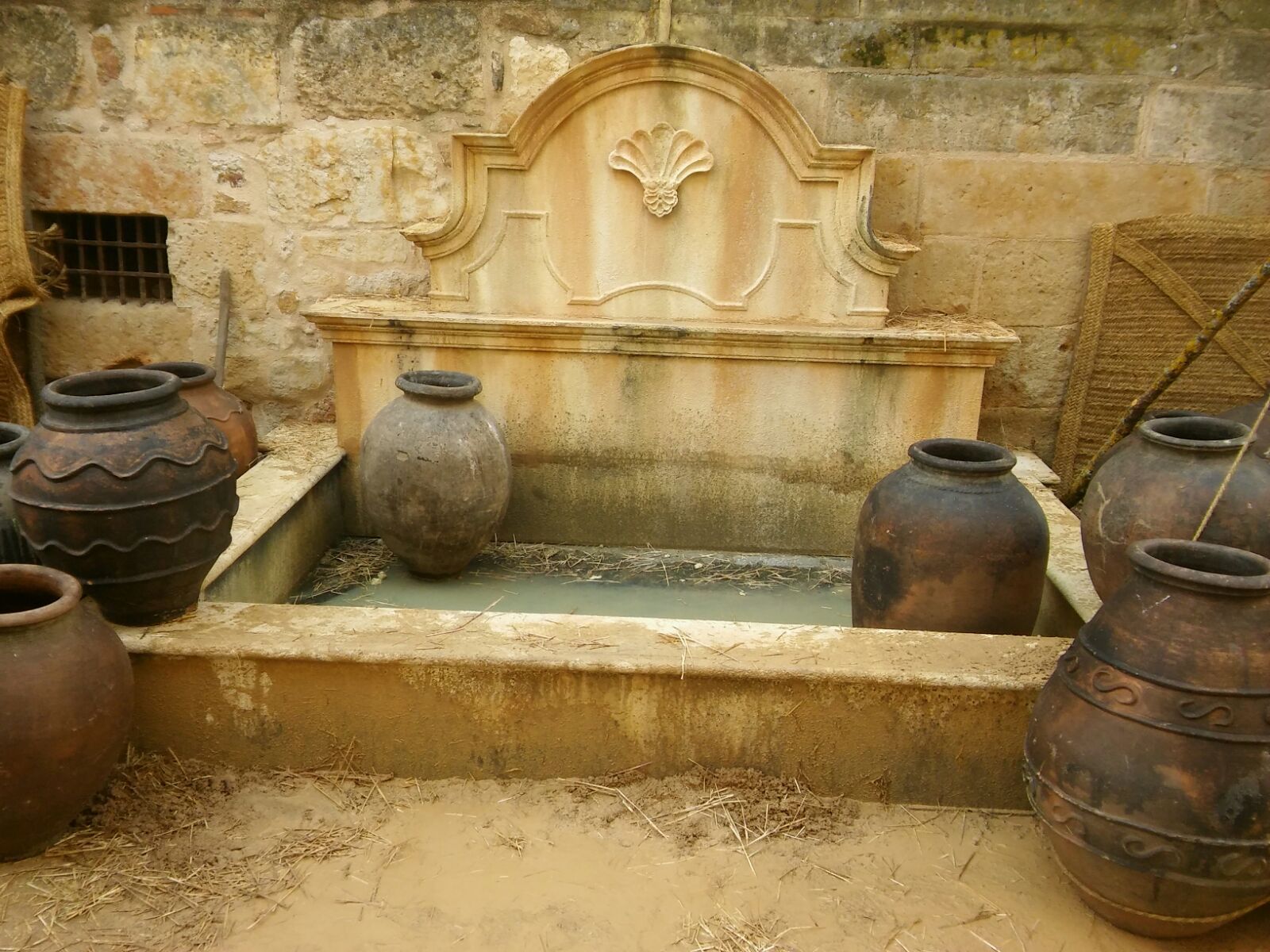 Una fuente con muchas macetas delante de ella.