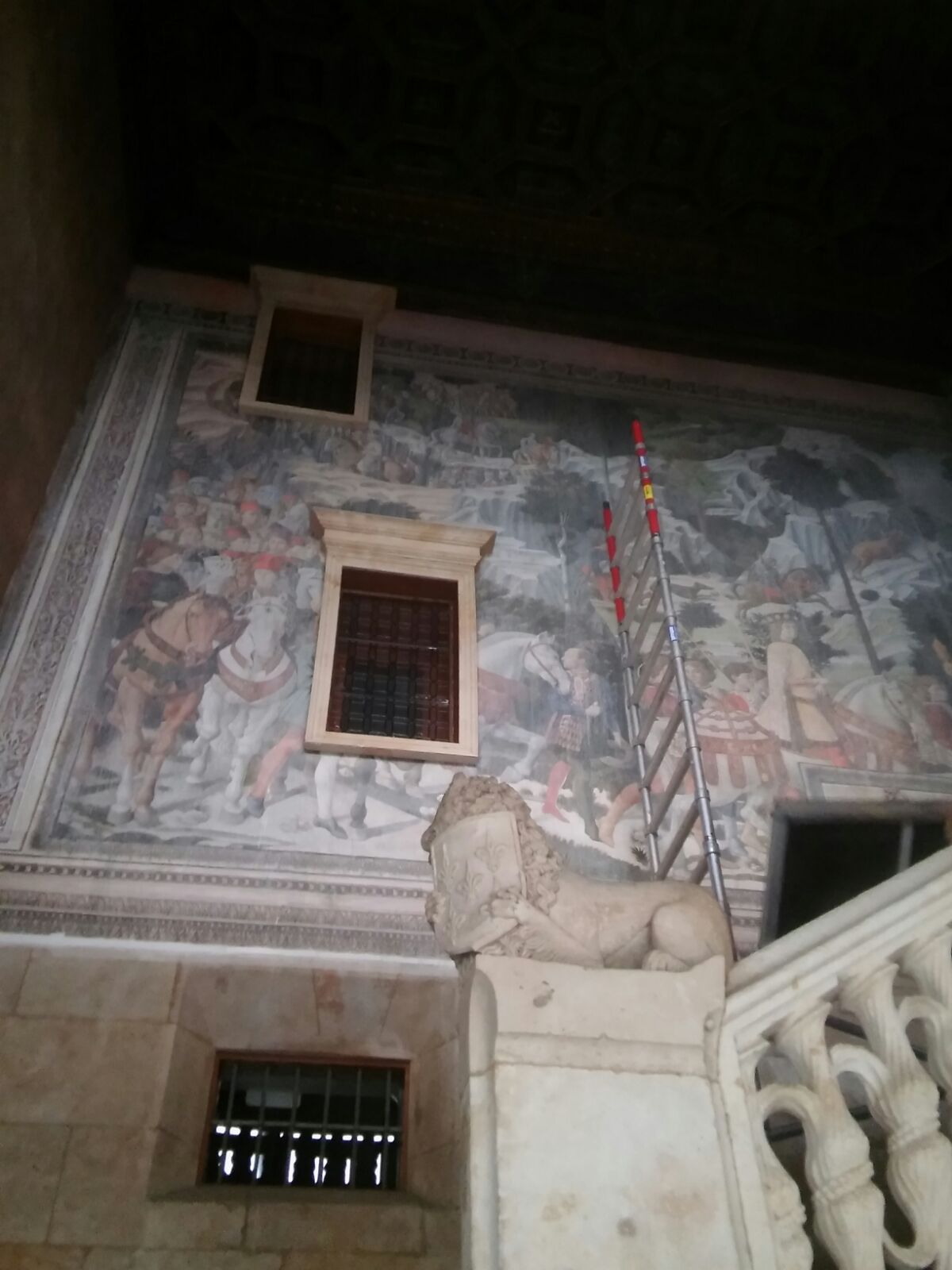 Hay una estatua de un león en el costado de un edificio.