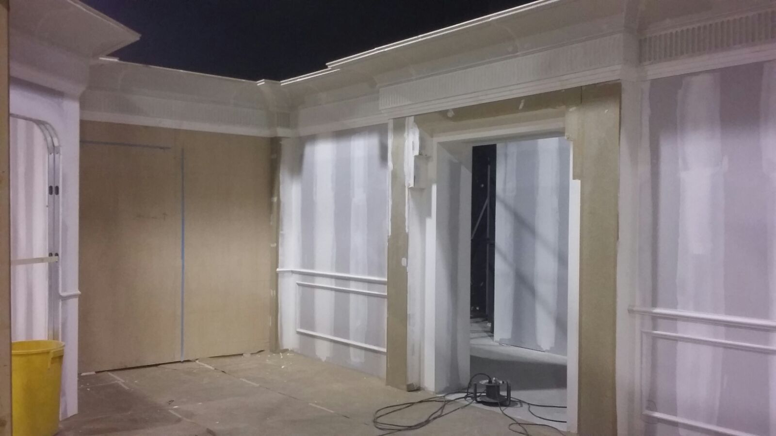 Un edificio en construcción con una aspiradora en el medio de la habitación.