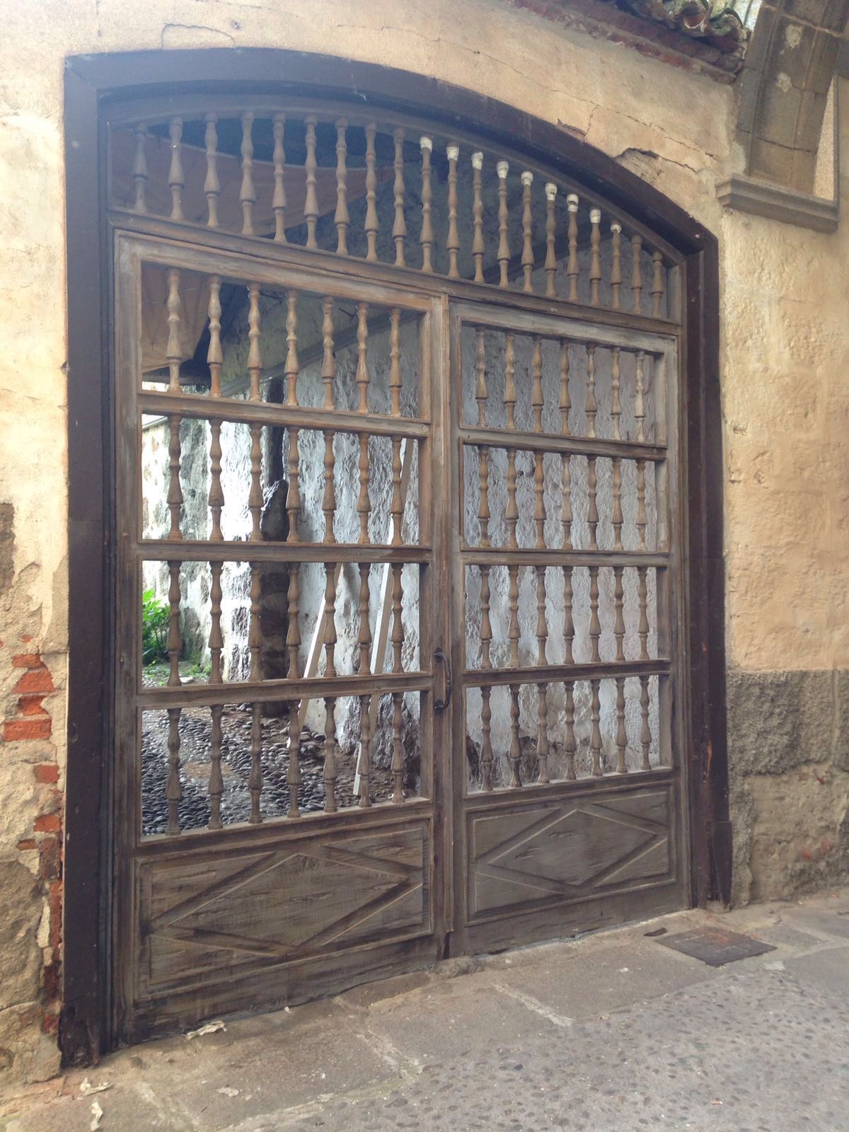 Una puerta de madera con una valla de hierro forjado a su alrededor.