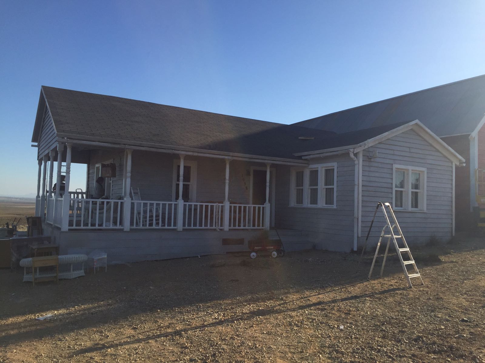 Una casa con un porche y una escalera delante de ella