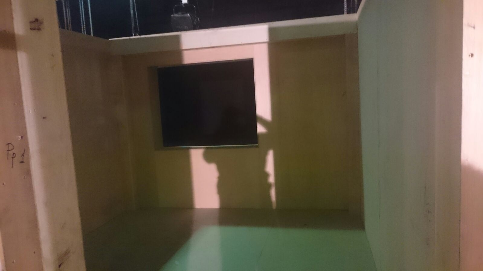 La sombra de una persona se proyecta sobre una pared en una habitación vacía.