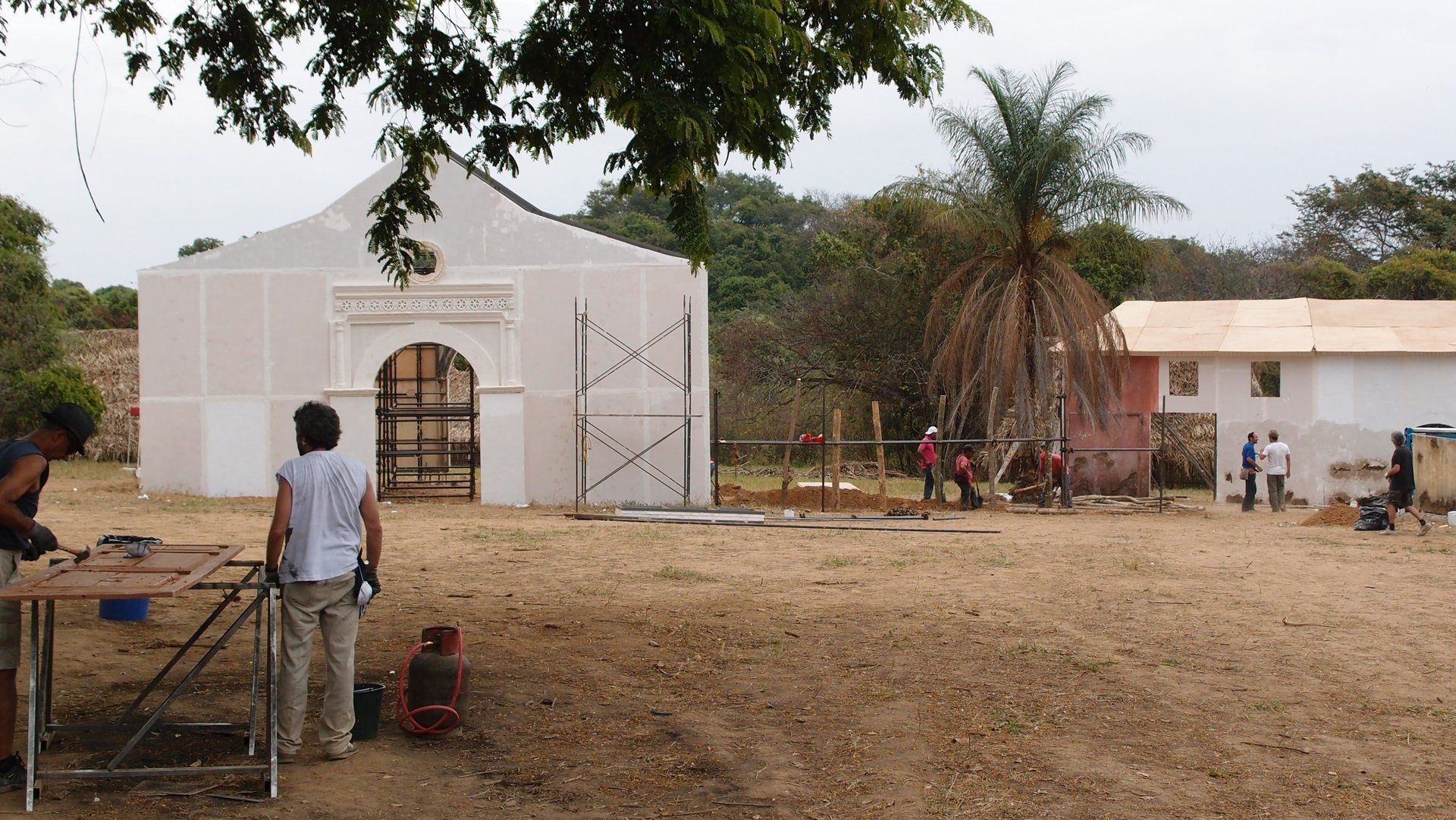 Un grupo de personas está trabajando en un edificio en un campo.