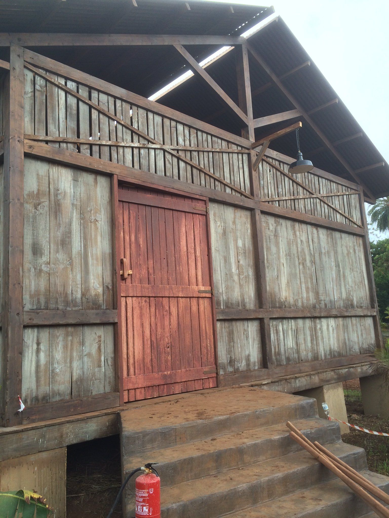 Un edificio de madera con una puerta roja y escaleras.