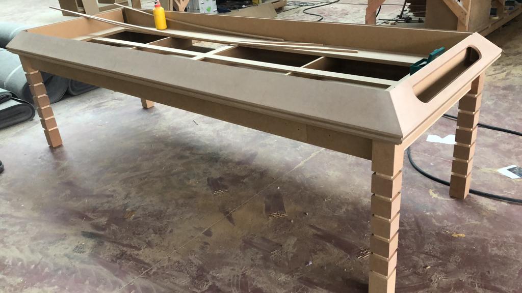 Una mesa de cartón está colocada sobre un suelo de hormigón.