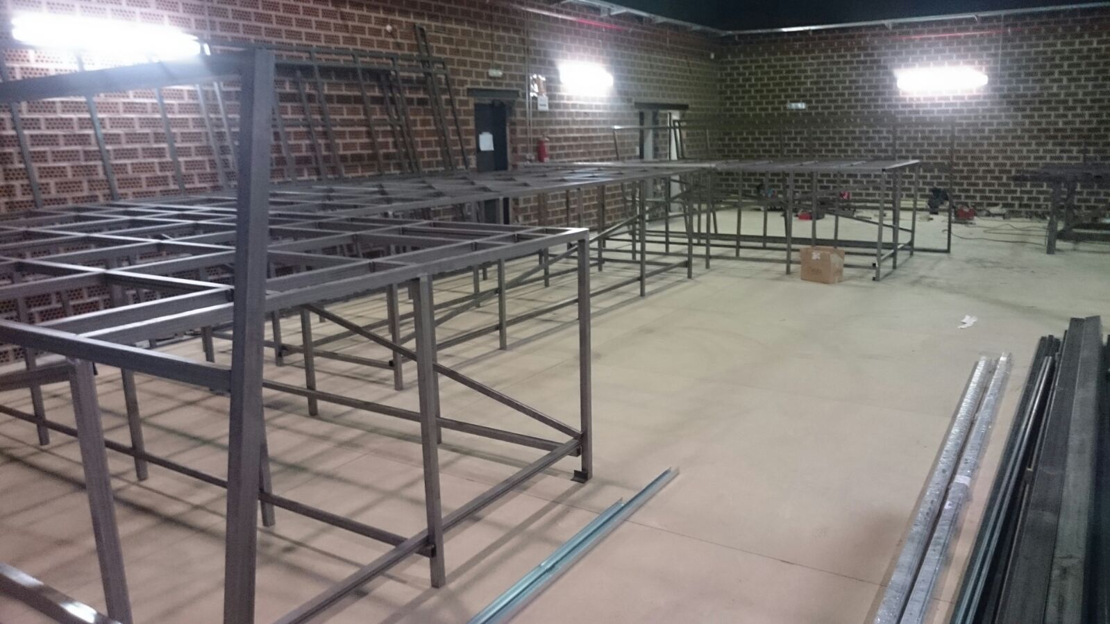 Un almacén lleno de muchos marcos de metal y paredes de ladrillo.