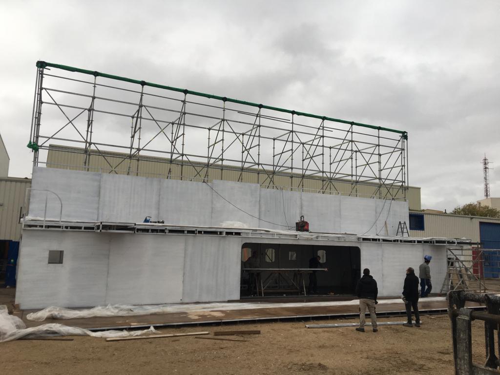 Se está construyendo un gran edificio blanco con techo verde.
