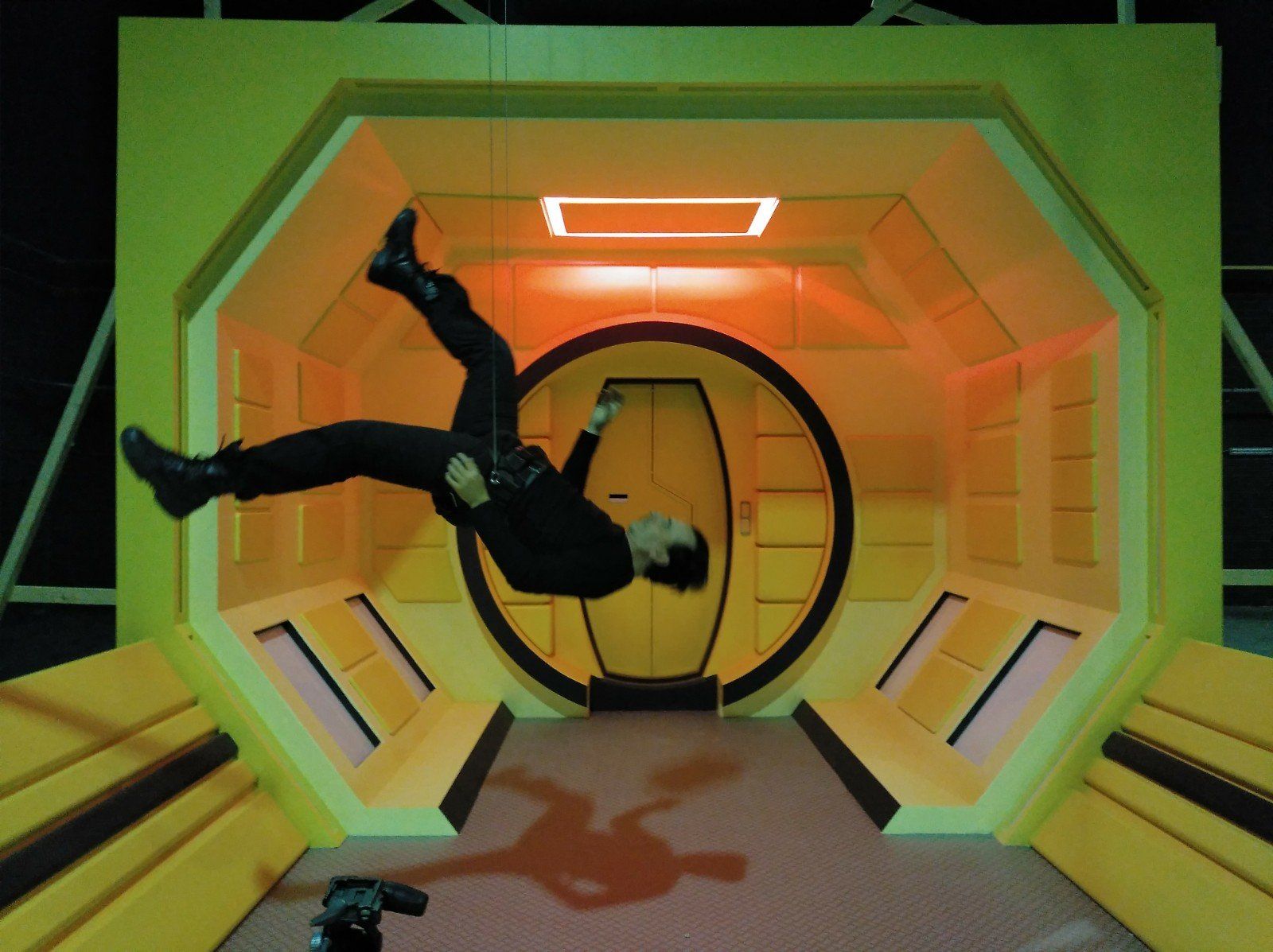 Un hombre está haciendo una parada de manos en una habitación amarilla.