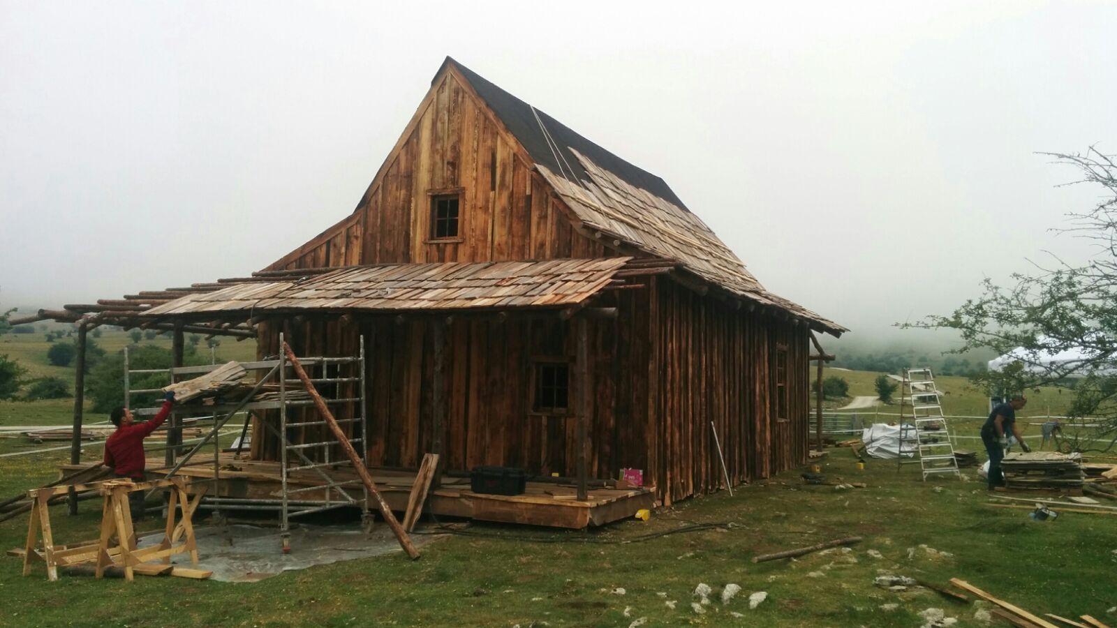Se está construyendo una casa de madera en medio de un campo.