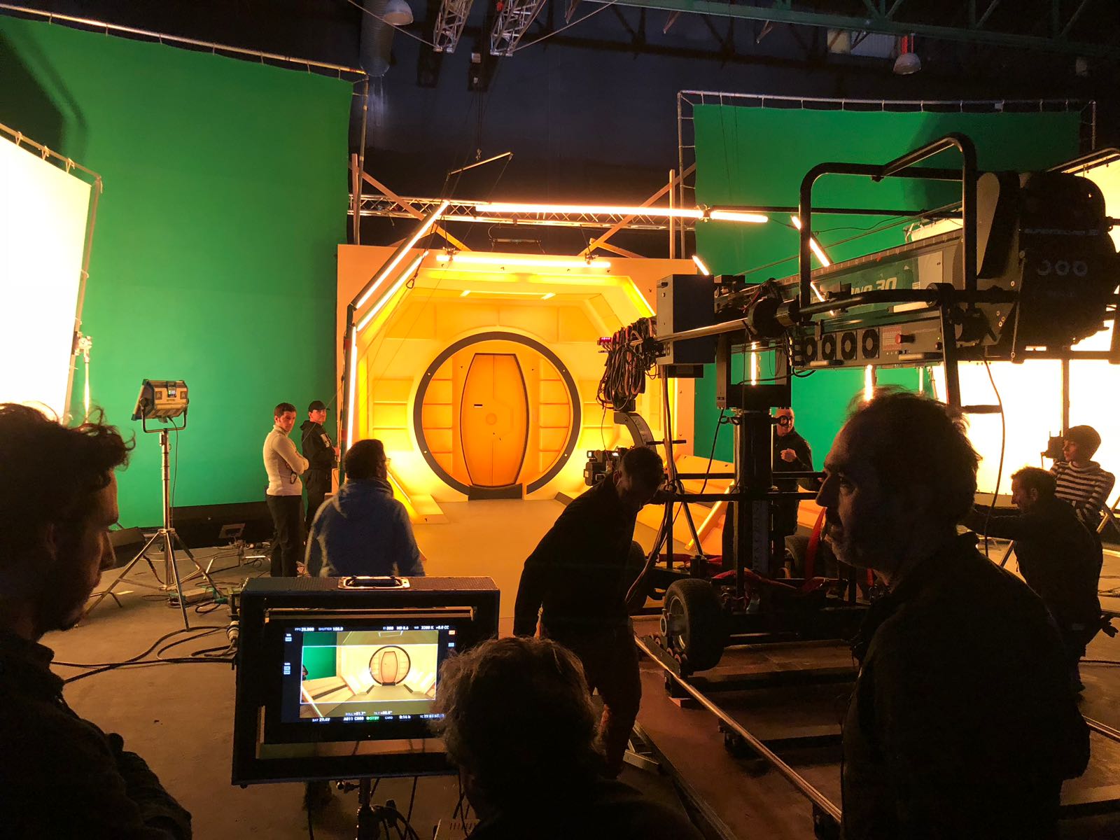 Un grupo de personas está de pie frente a una pantalla verde en un estudio.