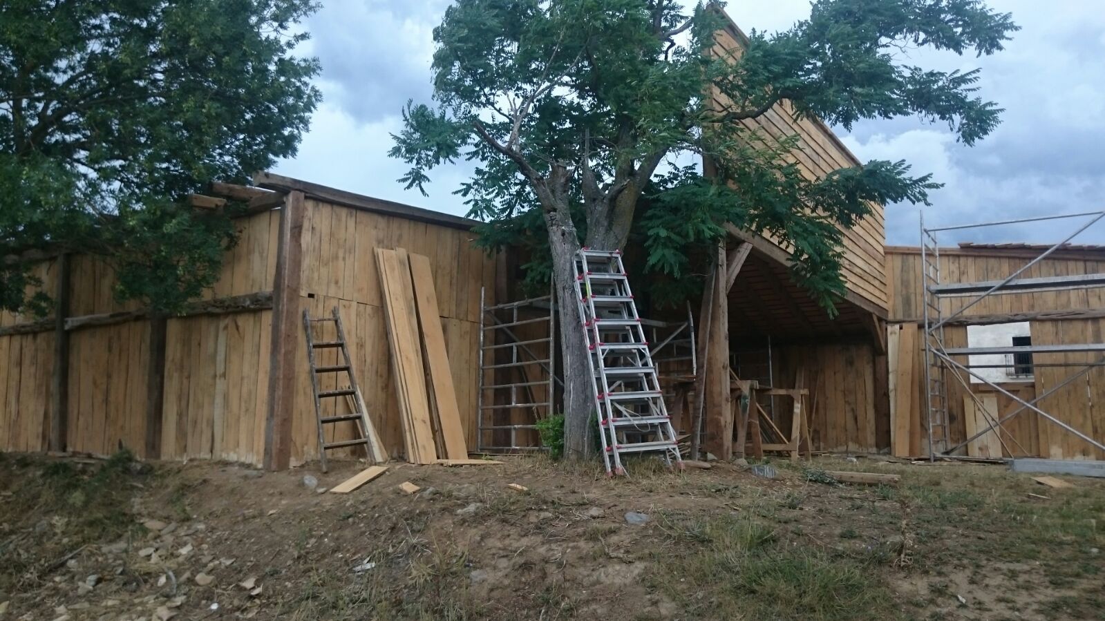 Una escalera está situada delante de un edificio de madera en construcción.