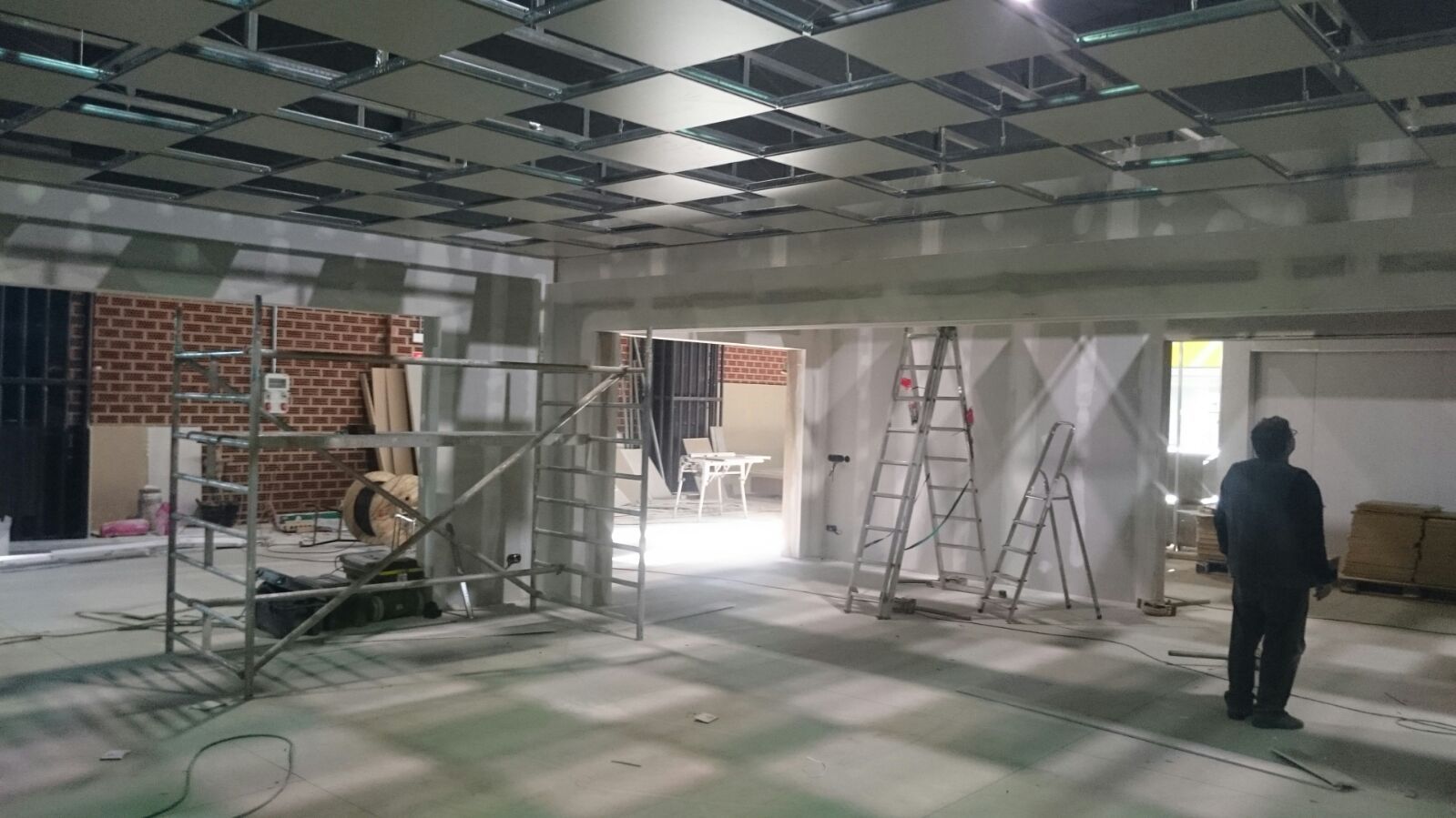 Un hombre está de pie en una gran habitación en construcción.