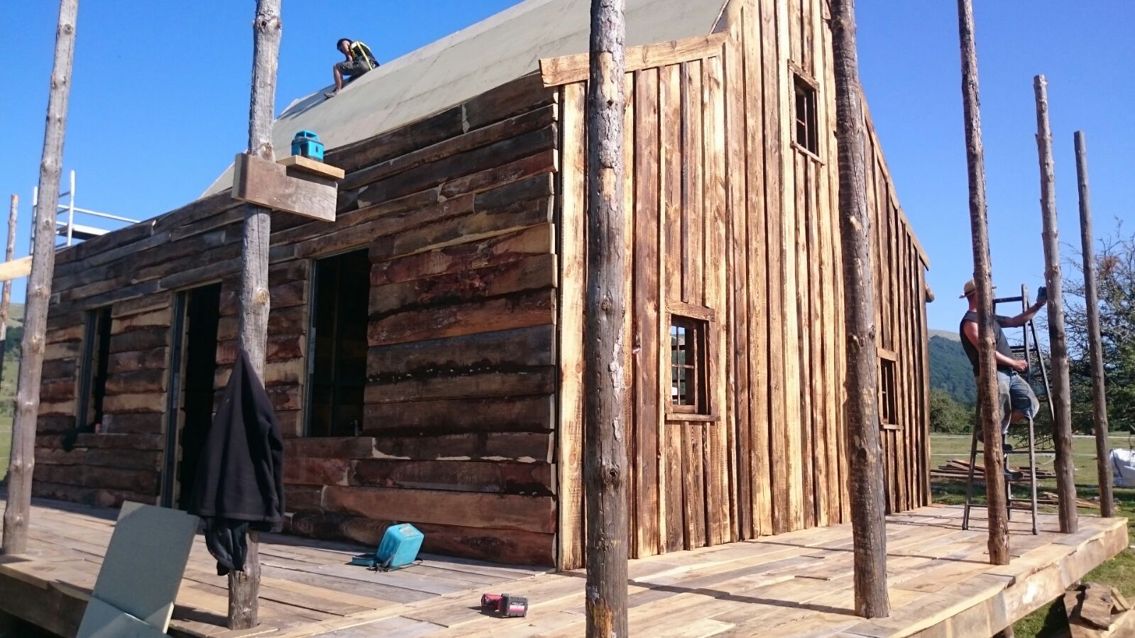 Un grupo de personas está trabajando en una cabaña de troncos.