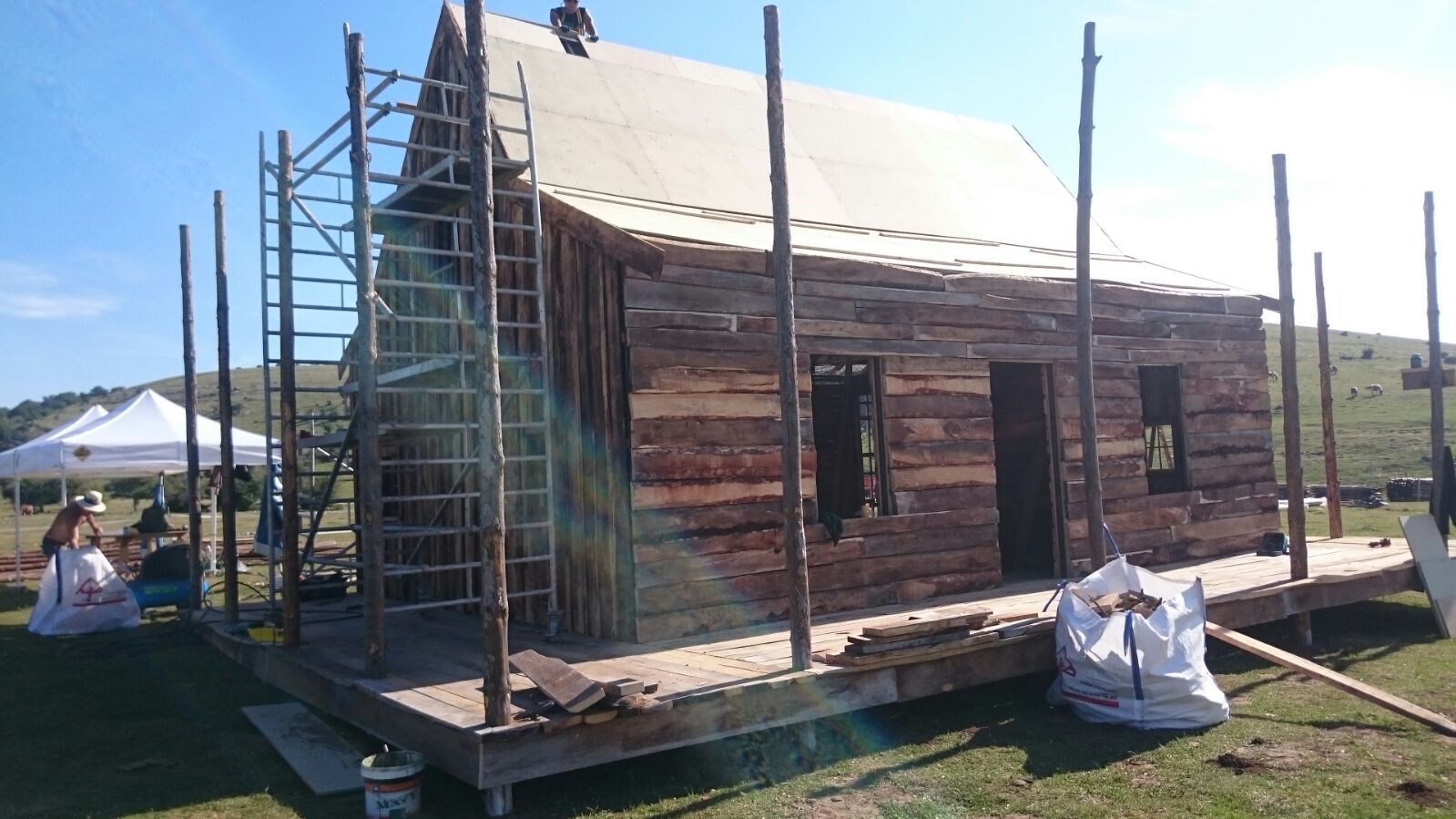 Se está construyendo una cabaña de troncos en un campo con andamios.